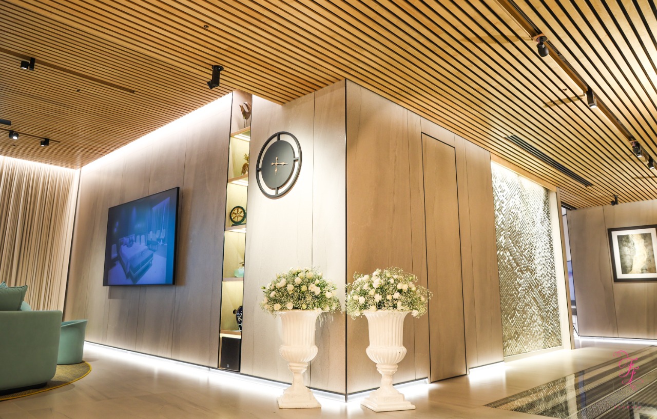 Timber ceiling with track lights and warm cove lighting under a display niche in a home